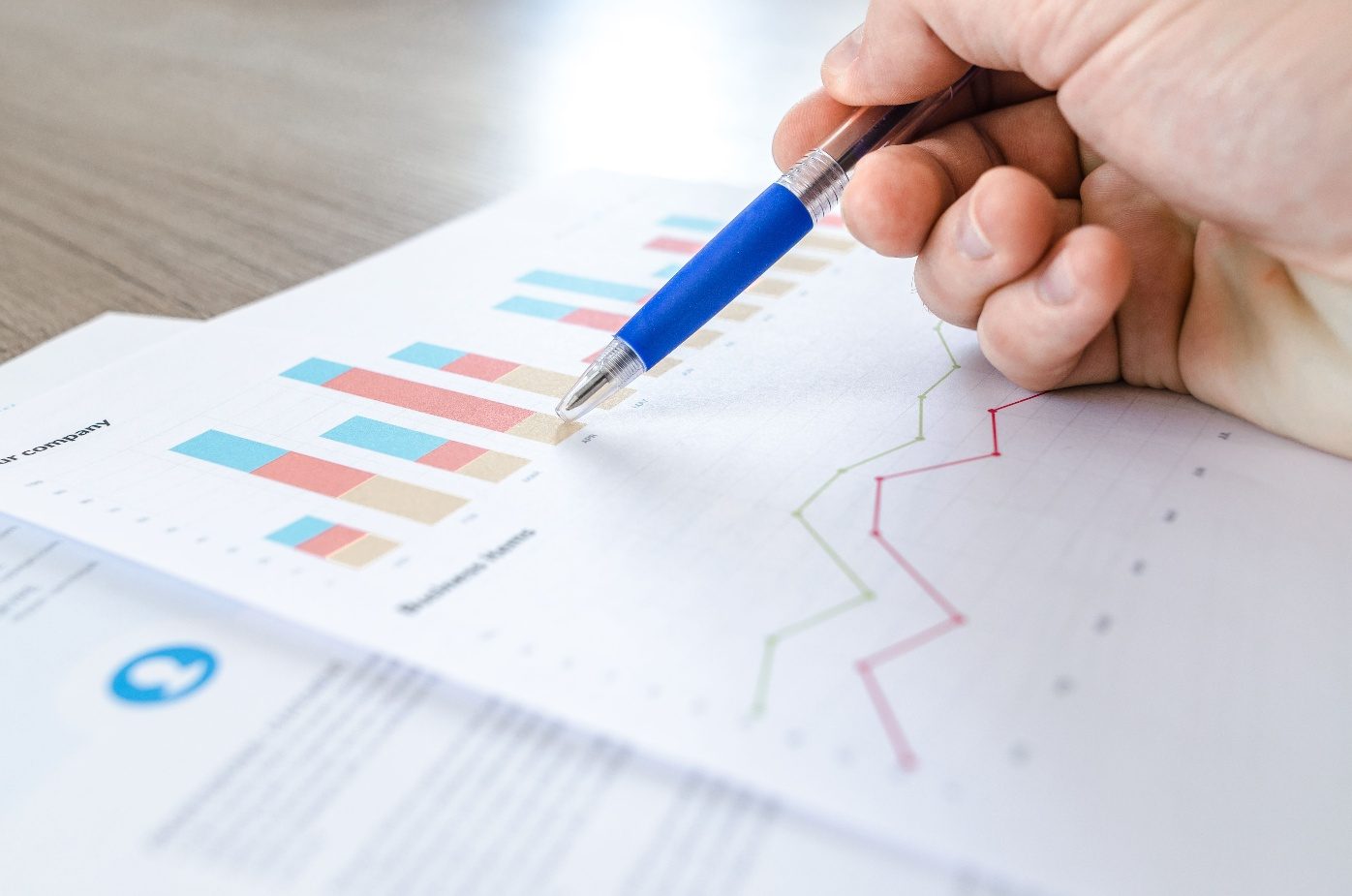 Reviewing printed business performance charts with a pen